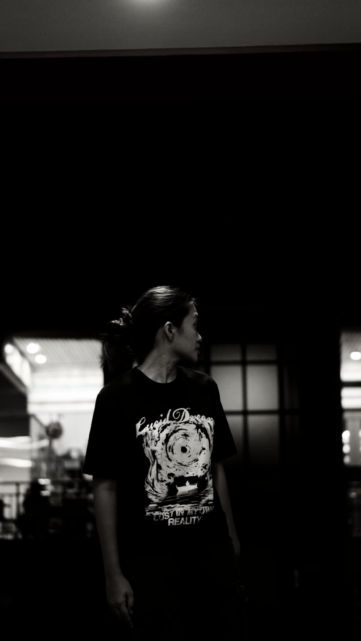 A model in the LD Signature Shirt in Black, looking back over her shoulder